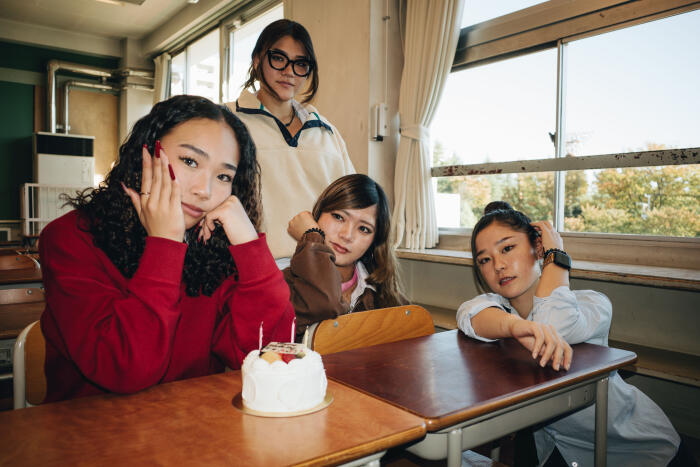 A group of schoolgirls gave their best friend a beautiful birthday cake. They made a wish together and shared their happiness.