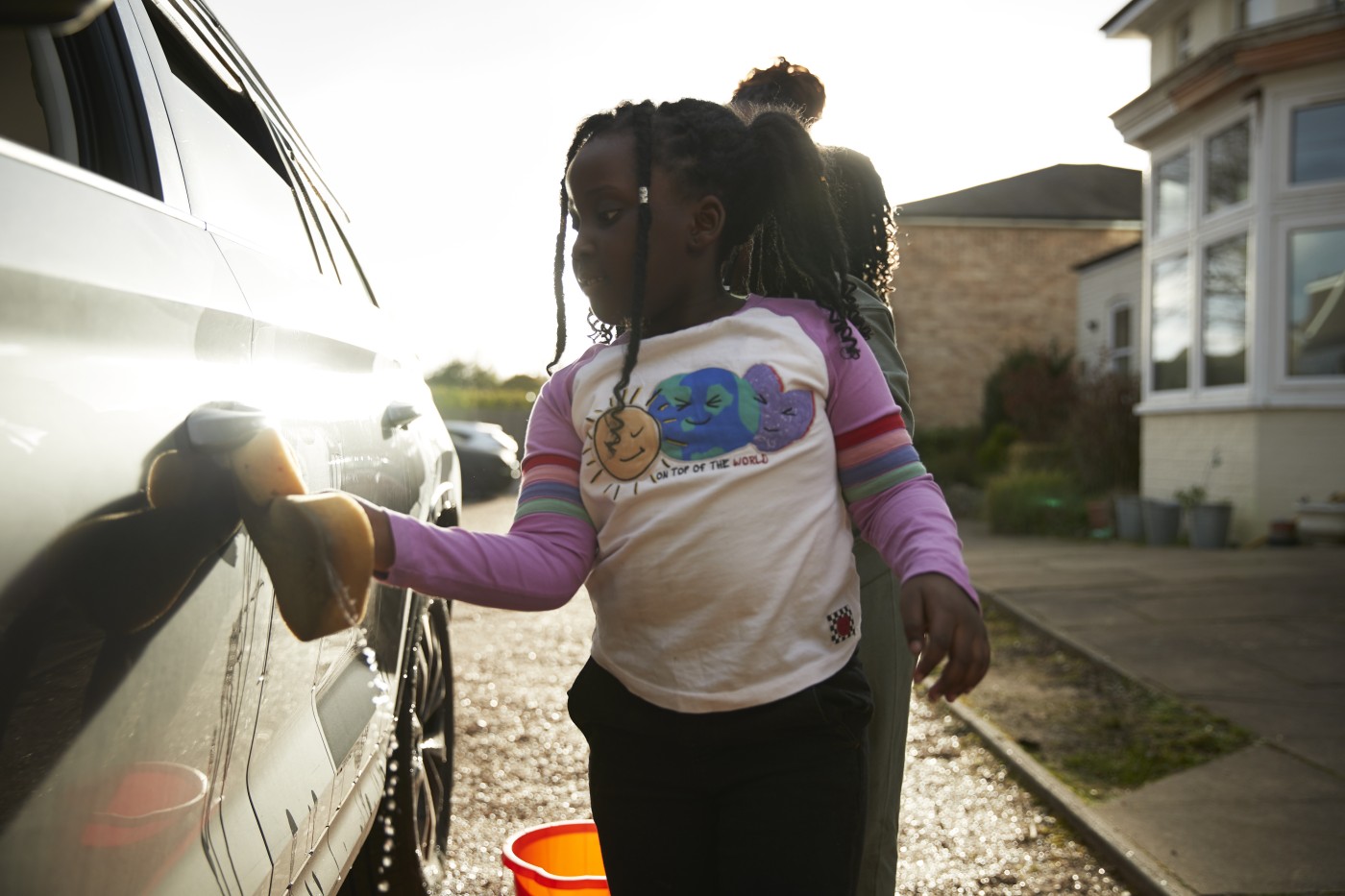 mother and daughters cleaning car
