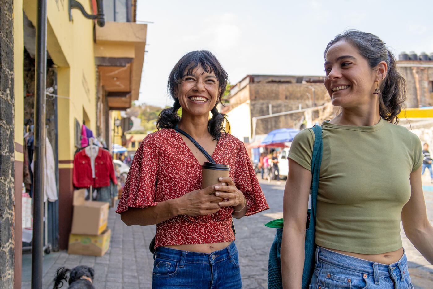 Two female friends walking in a street in a small town in mexico