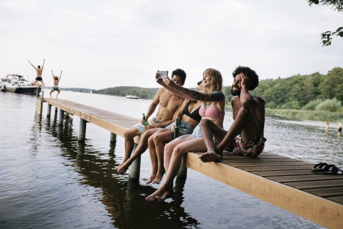 Friends Taking Selfie On Lake Pier