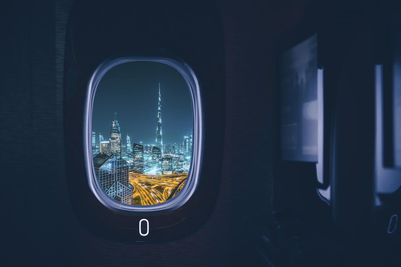 Dubai city seen through an aircraft window at night.