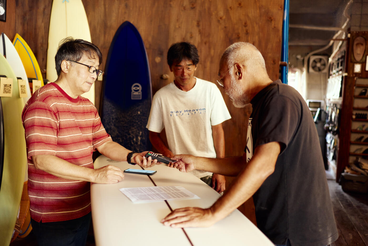 Male customer making a contactless payment with a debit or credit card.