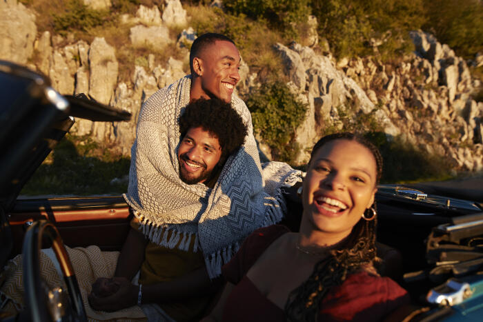 Woman by male friends wrapped in blanket