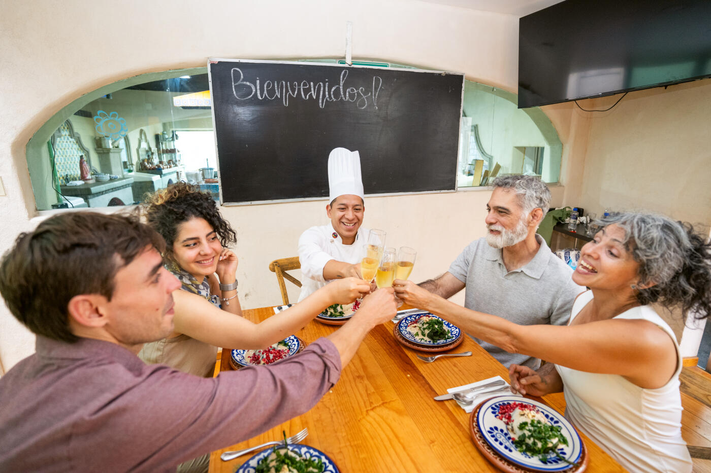 Group of friends toast to celebrate a successful cooking class were they made chiles en nogada