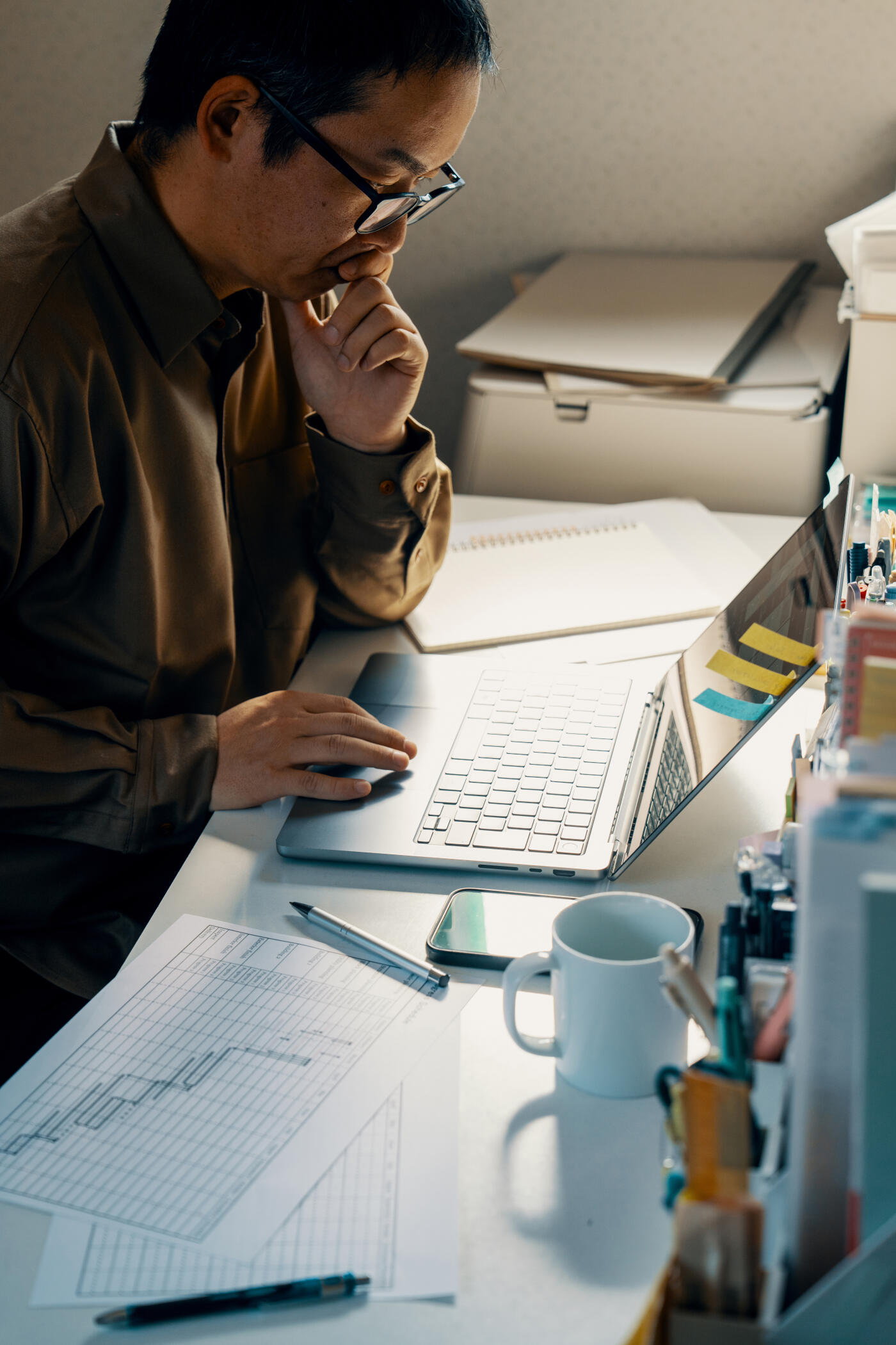 Mid adult man preparing taxes in a cluttered office