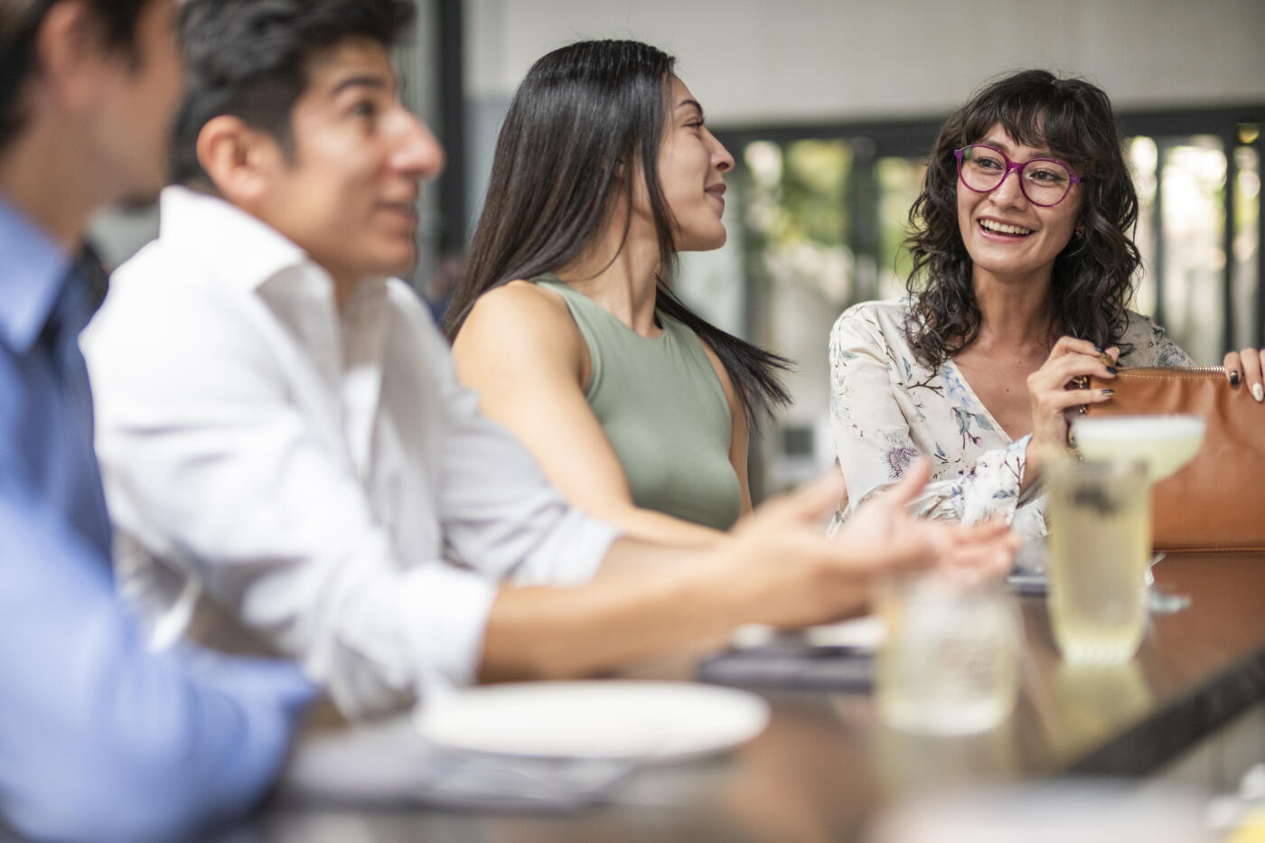 A group of young professionals taking advantage of their free time after a day's work to enjoy a meal with friends in a modern and elegant restaurant.