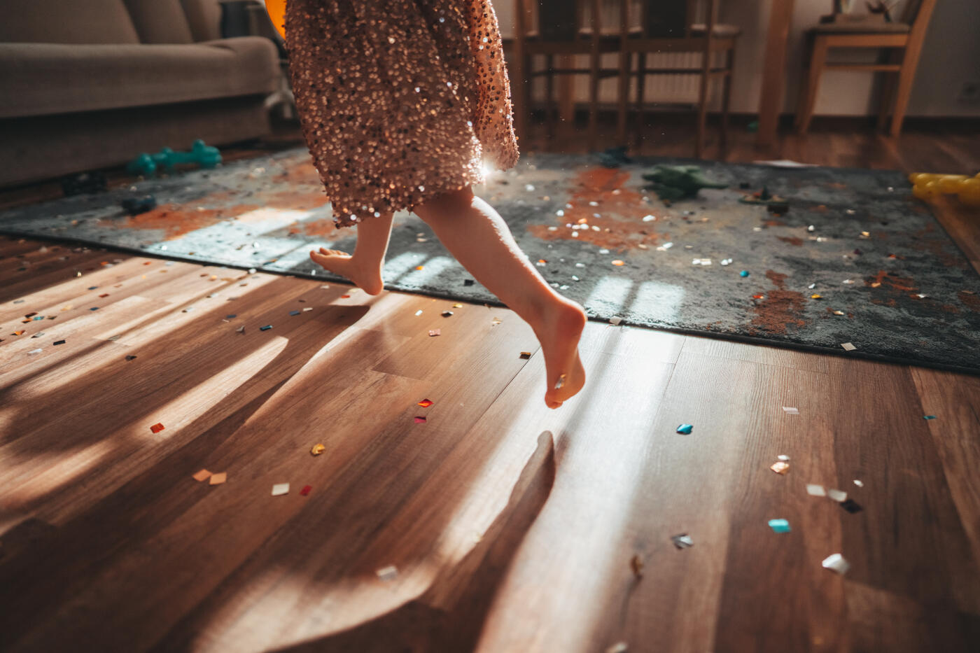 Legs of a girl in a sparkling skirt among confetti. Celebration concept. Children's birthday. Party at home