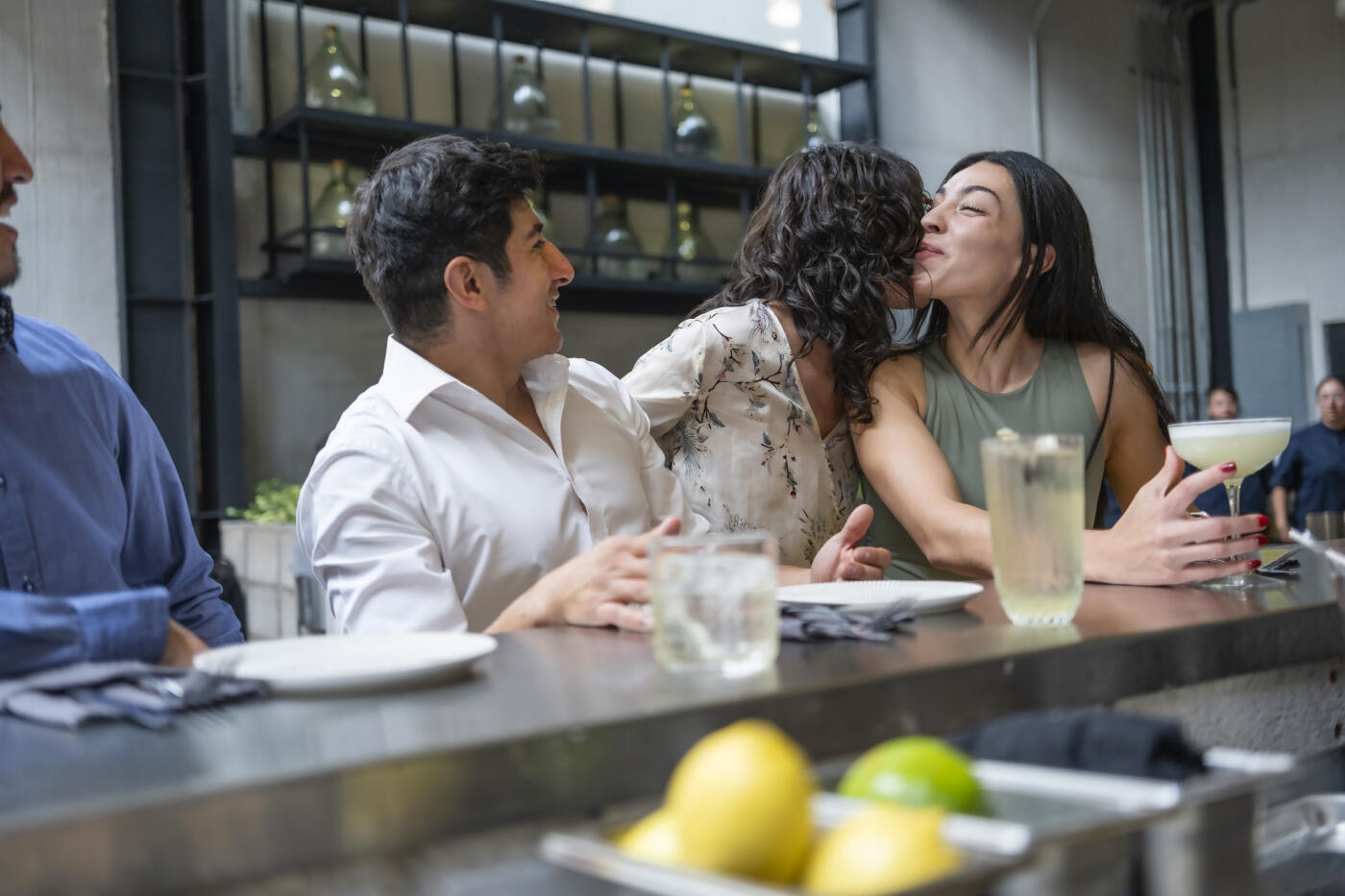 A group of young professionals taking advantage of their free time after a day's work to enjoy a meal with friends in a modern and elegant restaurant.