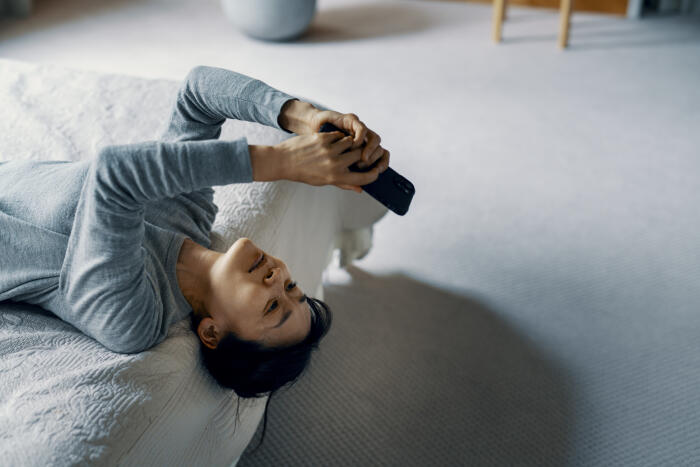 Adult female lays on bed and video calls negative emotion