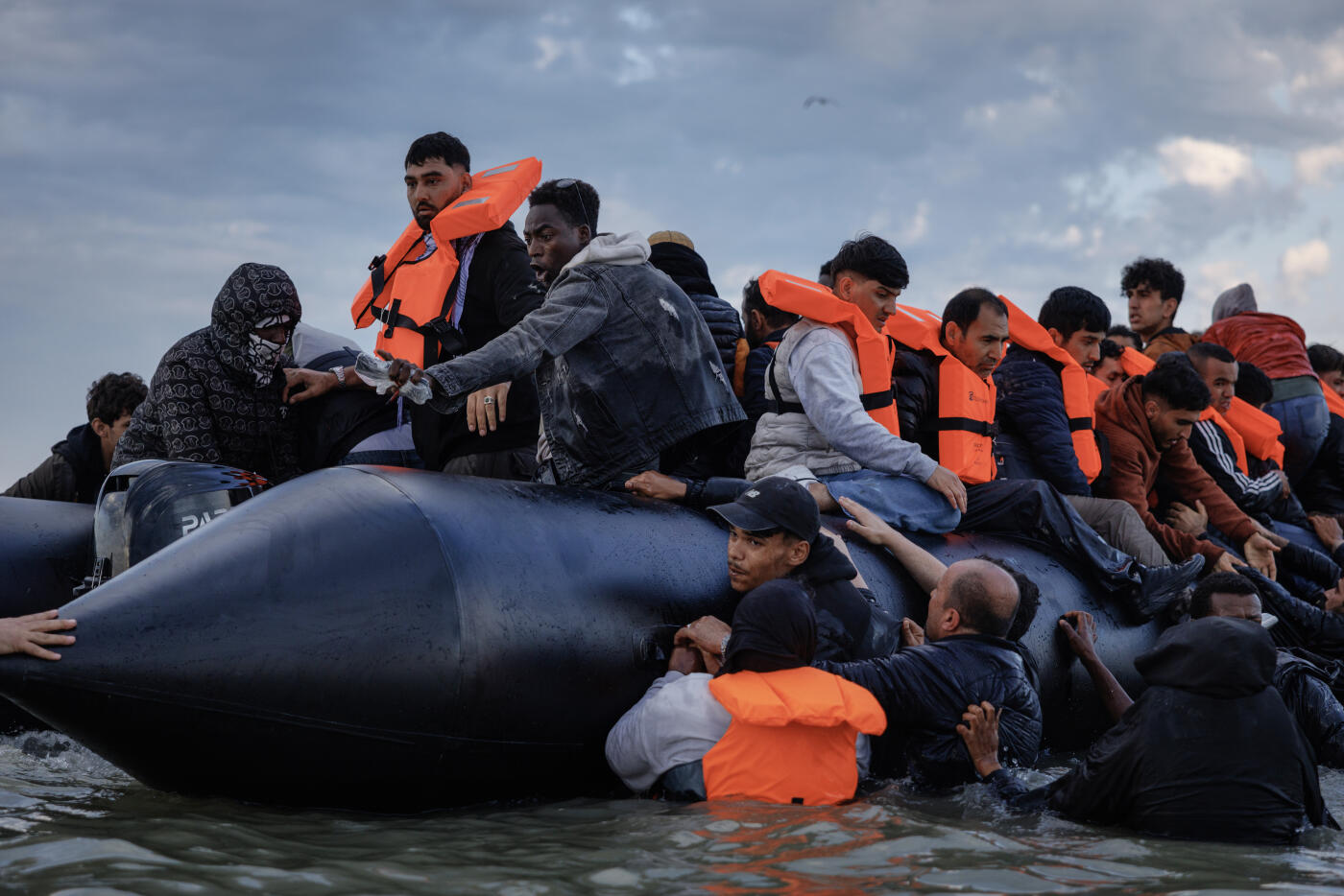 GRAVELINES, FRANCE - AUGUST 12: Migrant families wade into the sea in an attempt to board a small boat on August 12, 2025 in Gravelines, France. More than 50,000 small boat migrants have now crossed the English Channel since Labour came to power last July. Last week the UK and France began implementing the so-called 'one-in, one-out' treaty, which was agreed during French President Emmanuel Macron's state visit last month, in an effort to curb illegal migration across the English Channel. Under the pilot scheme, a proportion of undocumented people arriving to the UK in small boats will be returned to France, in exchange for the same number of legitimate asylum seekers who may have family ties in the UK.  (Photo by Dan Kitwood/Getty Images)