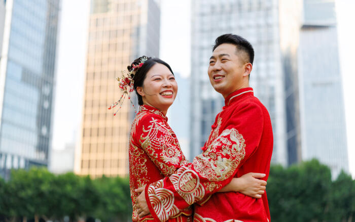 A Chinese newlywed couple in their 30s, wearing Hanfu costumes, hug each other in a modern city on their wedding day, traditional costumes and modern city concept