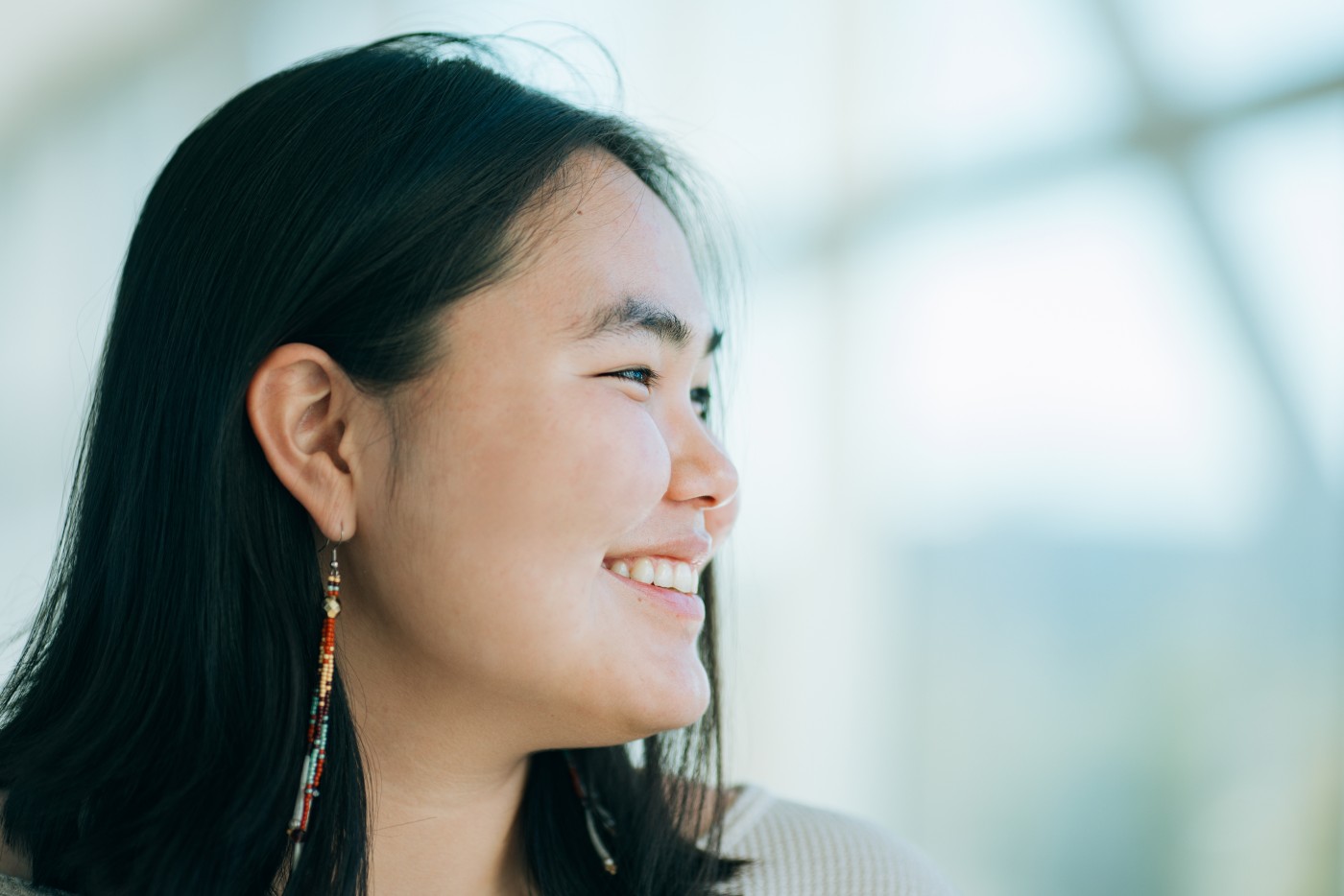 A smiling portrait of an Indigenous Alaskan woman indoors.  Shot in Anchorage, Alaska, USA.