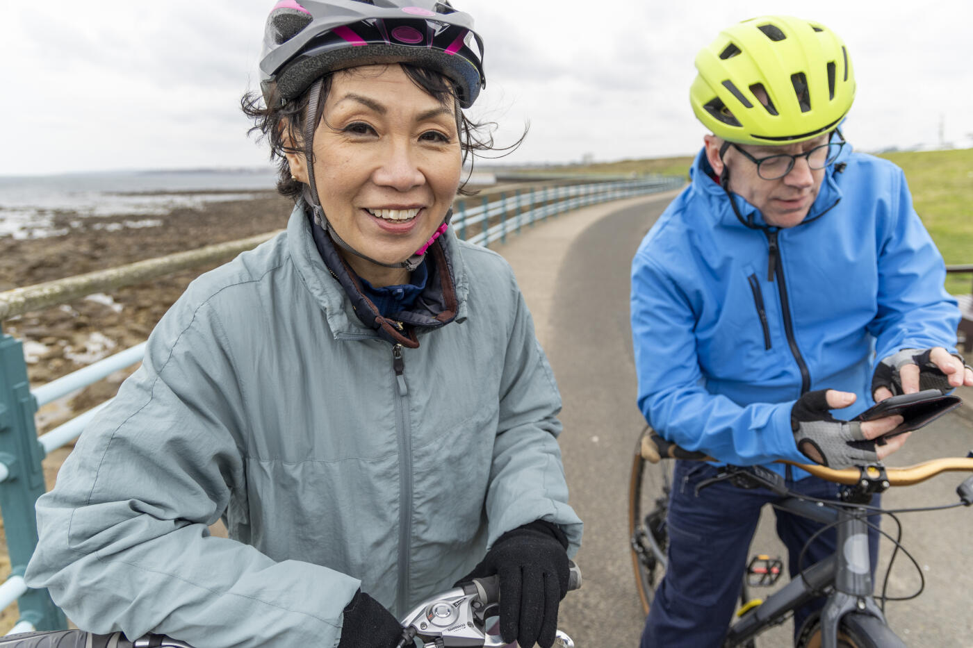 Senior couple enjoying a day out together cycling along the Northumberland coast