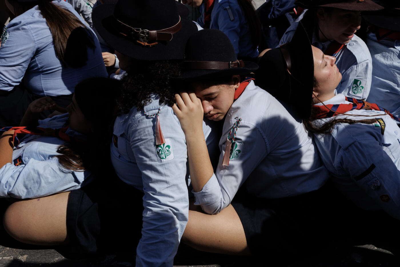 ROME, ITALY - APRIL 27: A group of scouts rest on the floor outside the Vatican as faithful queue for the Holy Mass on Divine Mercy, on the second day of mourning for Pope Francis on April 27, 2025 in Rome, Italy. Funeral rites for the late Pope Francis are held for nine days after his burial as he is mourned and celebrated by the faithful. The congregation was made up of tens of thousands of youths taking part in the Catholic jubilee year. During this time, the Vatican prepares for the process to elect a new Pope, known as the Conclave, which must begin within 15 to 20 days of the Pope's death.  (Photo by Dan Kitwood/Getty Images)