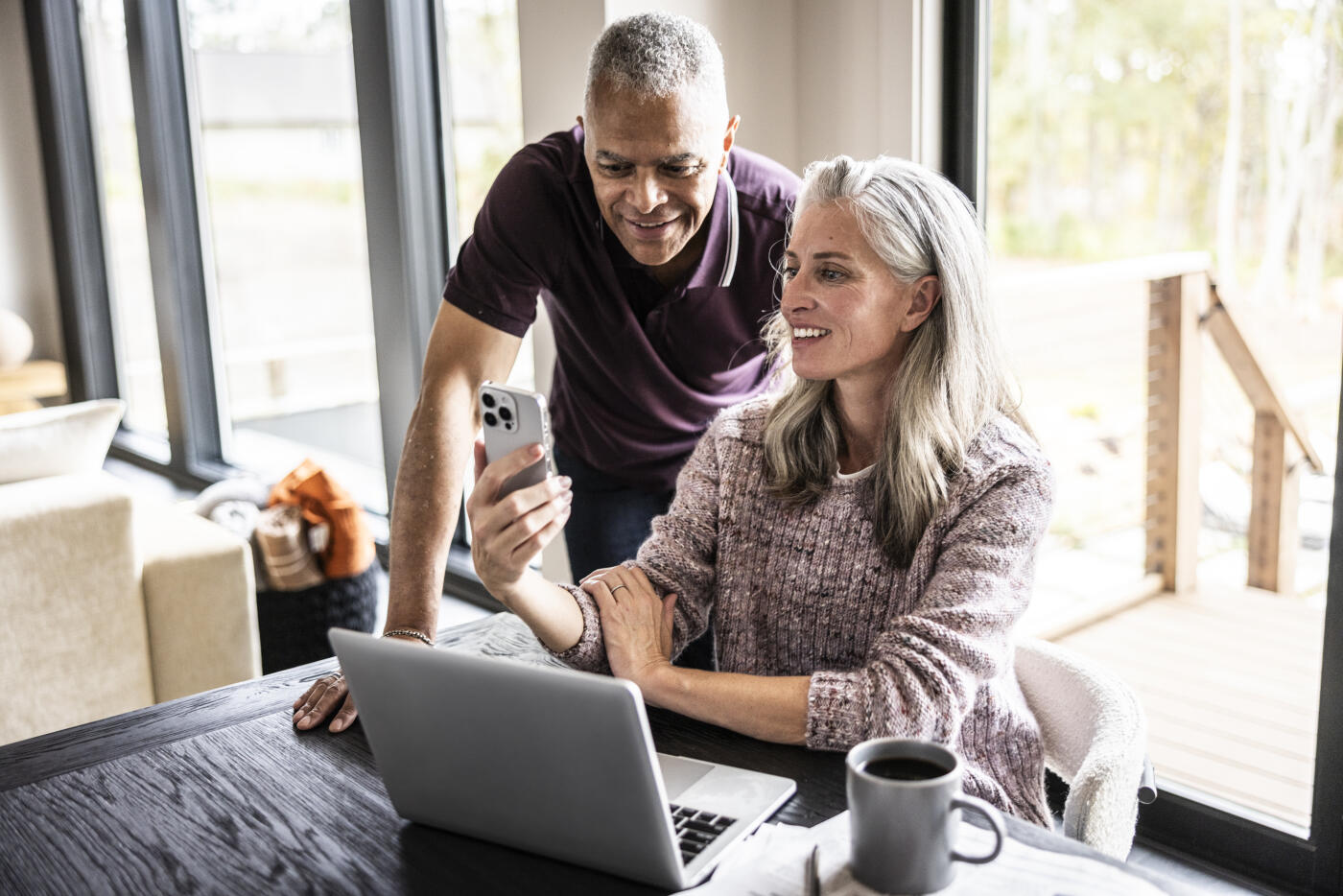 Senior couple using laptop and smartphone at home