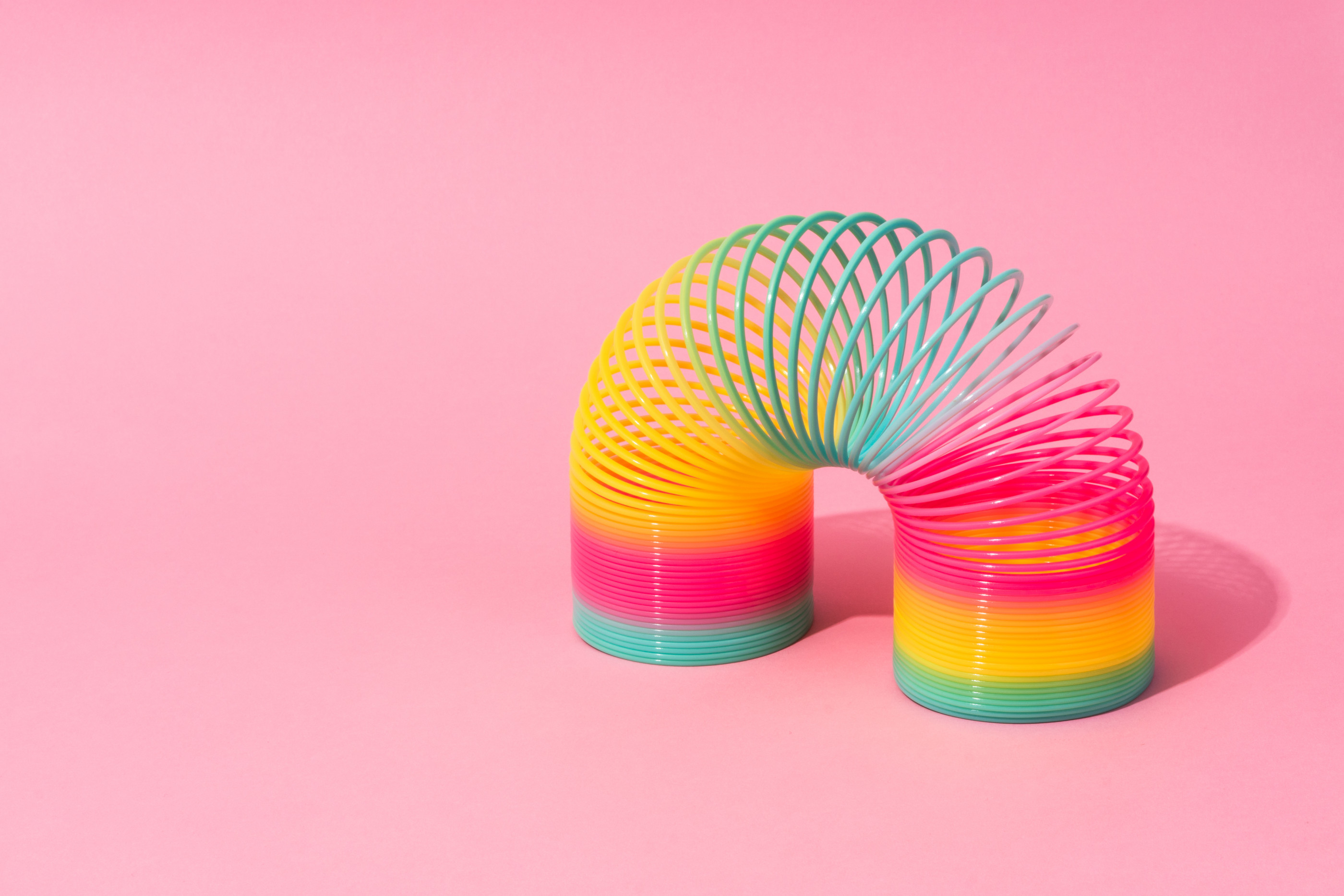 Rainbow Coil Toy on Pink Background.