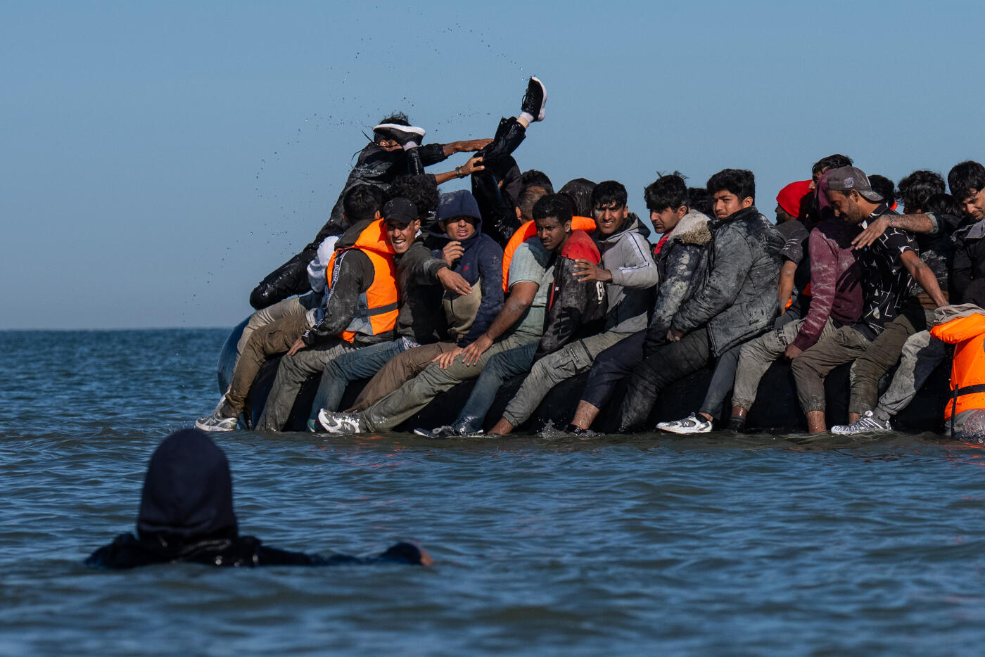 GRAVELINES, FRANCE - AUGUST 25: Migrants board a dinghy into the English Channel on August 25, 2025 in Gravelines, France. Migrant crossings by boat have caused much controversy in the UK, with far-right groups organising demonstrations outside hotels housing migrants across the country over the summer. As of late August 2025, more than 28,000 migrants have crossed the English Channel in small boats this year. (Photo by Carl Court/Getty Images)