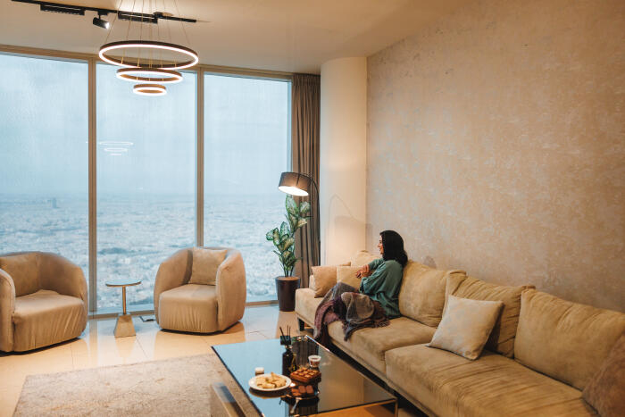 Mid Adult Arabic Female Relaxing in Luxurious Living Room with Riyadh Cityscape View