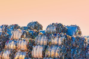 Large group of piles of crushed plastic bales stacking in a recycling plant.