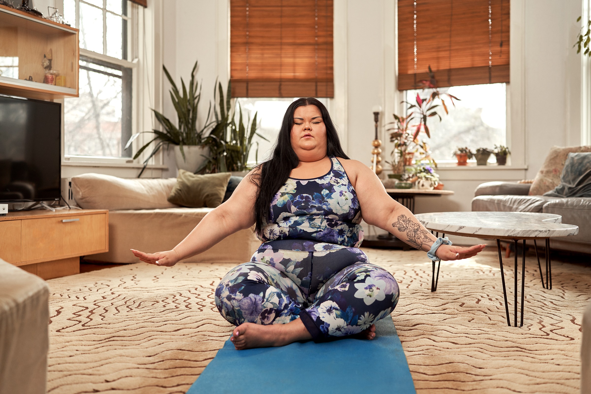Pacific Islander plus size woman living in modern apartment is content in her body and enjoys her life.