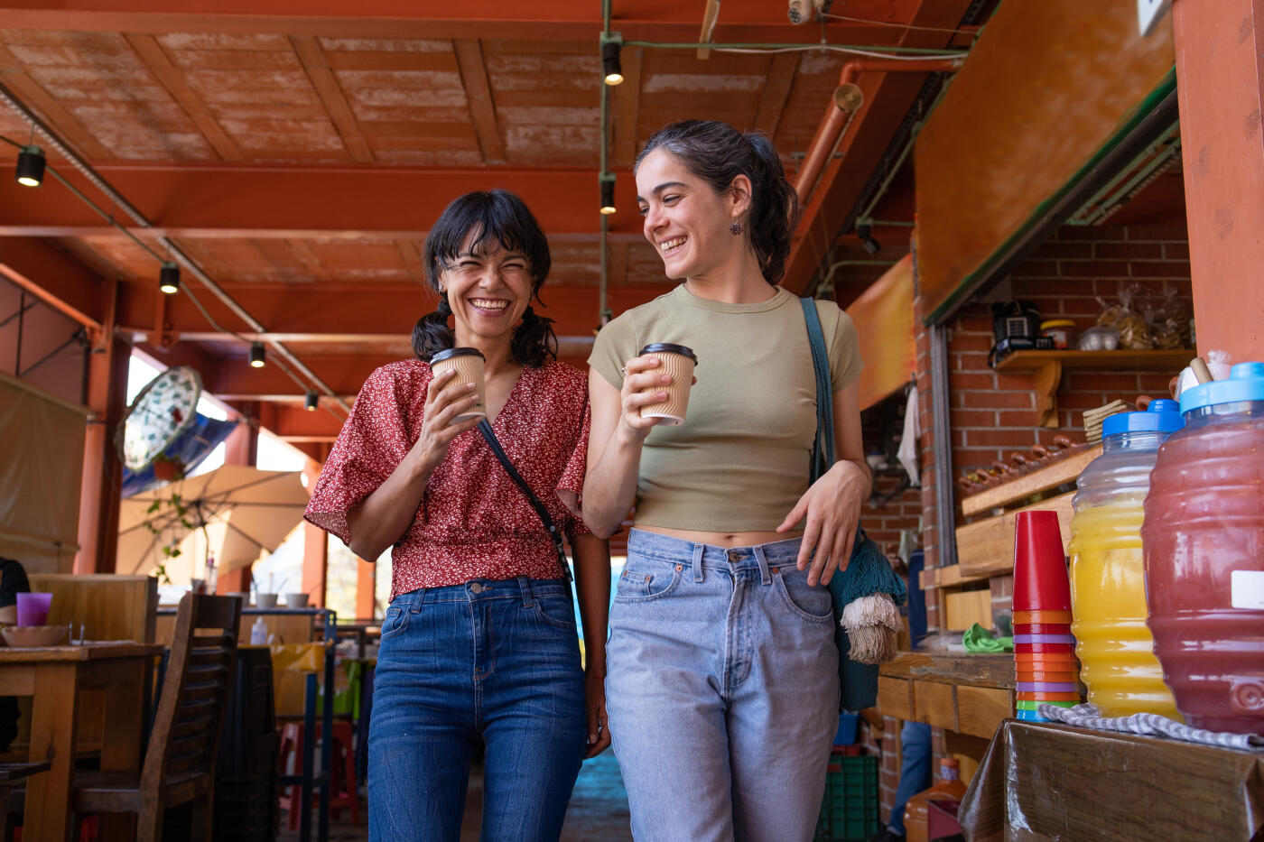 two women friends talking and walking while getting coffee