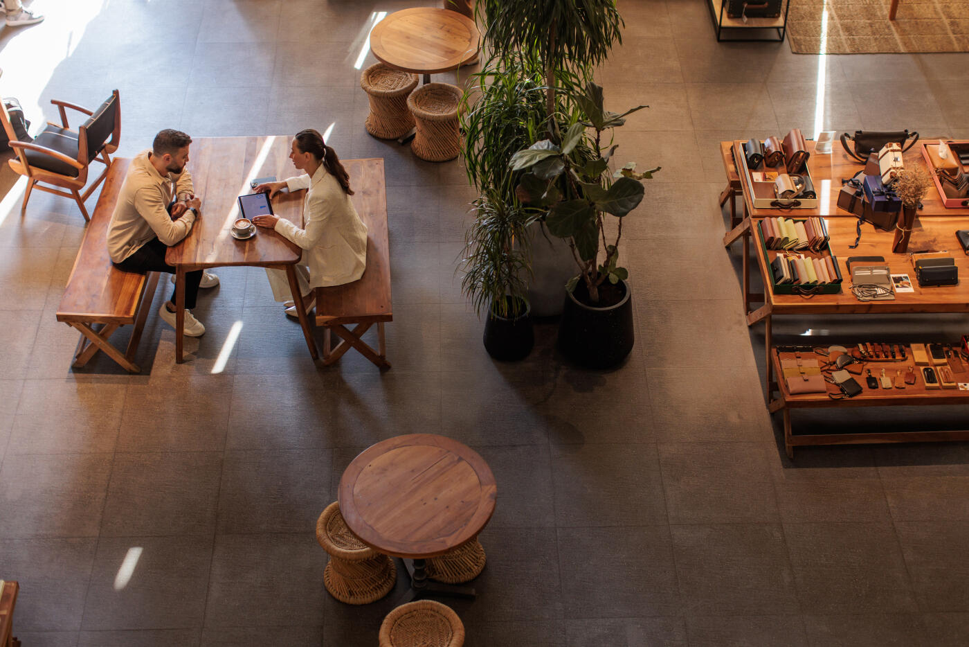 Modern man and woman sharing a digital tablet in a stylish café-boutique space in Dubai.