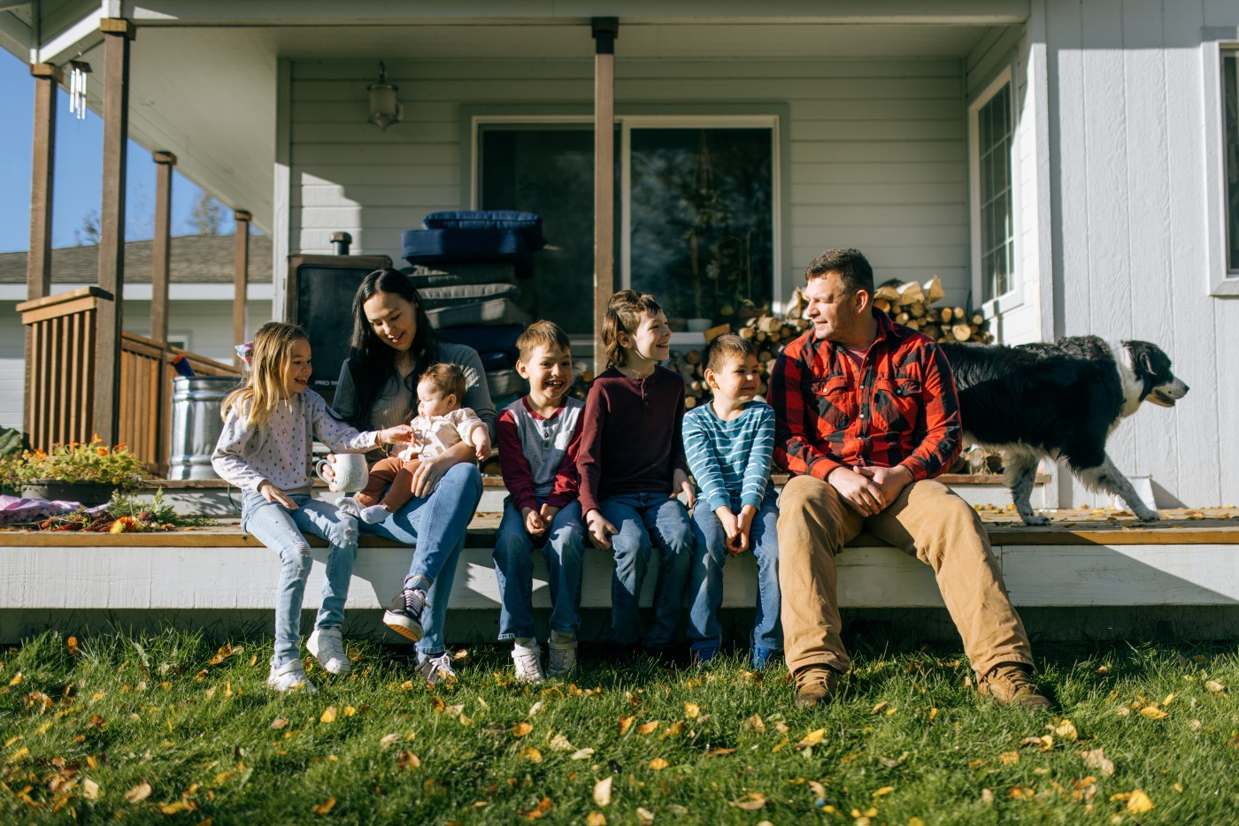 A young family, the father Caucasian and mother Indigenous North American, enjoy time together with their children at their house on a sunny day.  Shot near Palmer Alaska.