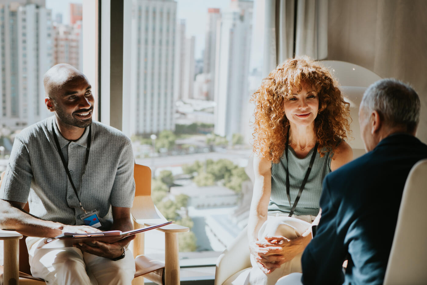 A diverse group of business professionals participates in a collaborative executive meeting in a modern office with panoramic city views. Team members engage in a productive strategy discussion, demonstrating leadership, communication, teamwork, and professional collaboration. The bright corporate setting and urban skyline create an ideal visual for business consulting, executive leadership, corporate culture, and strategic planning concepts.