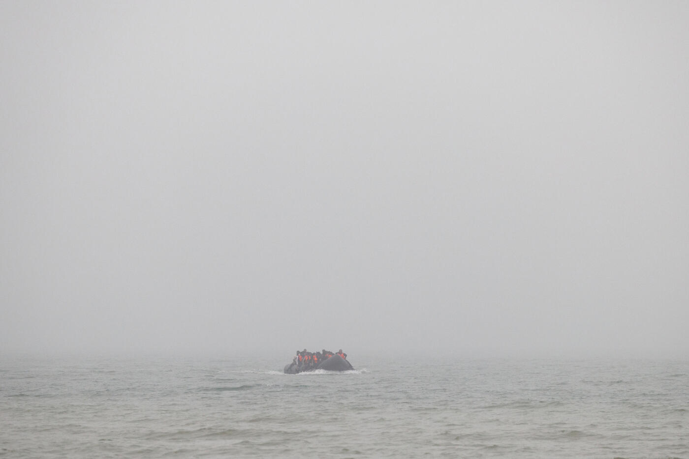 GRAVELINES, FRANCE - JULY 02: A small boat arrives through thick fog to pick up migrants at sunrise on July 02, 2025 in Gravelines, France. The boat had arrived through the fog, already very full of migrants who had boarded further down the coast, looking to squeeze a few more people in. Last month, it was reported that French officials were planning changes to policies that govern interceptions at sea, allowing police to intercept small boats within 300 metres of the French shoreline, in a bid to curb migrant crossings of the English Channel. The move, which has not been confirmed, would be welcomed by UK authorities, who see it as a step toward stronger border enforcement. (Photo by Dan Kitwood/Getty Images)