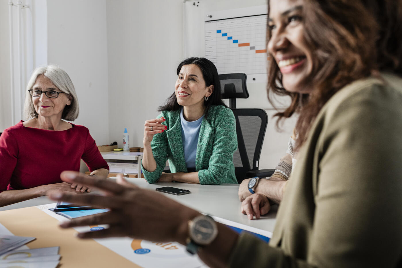 Diverse group of professionals engage in a lively, collaborative strategy meeting in a modern office.