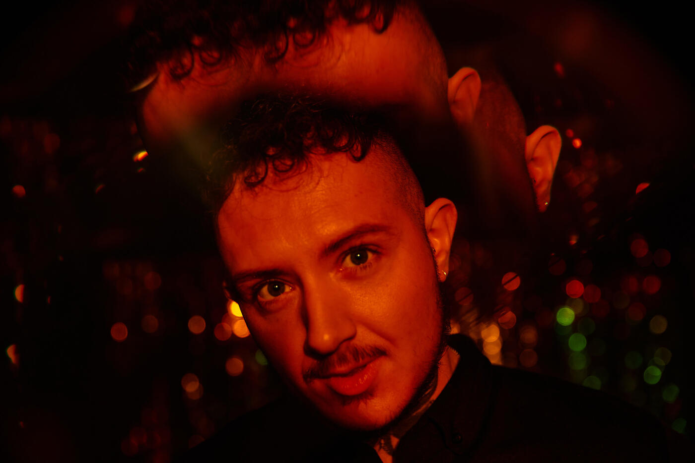 Man smiling to camera under red light with multi-vision effect