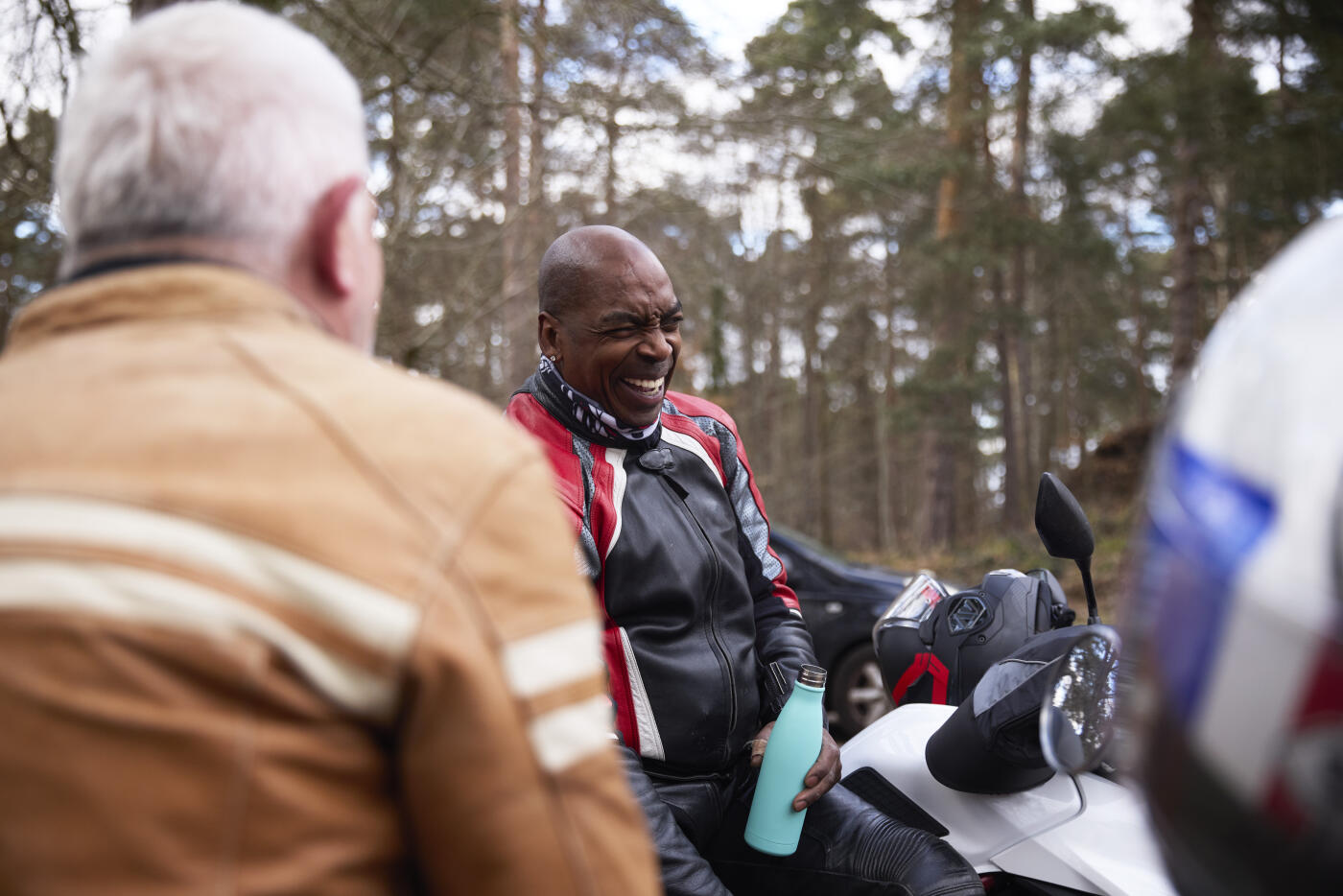 a couple of motorbikers in a rural rest stop chatting and having a break