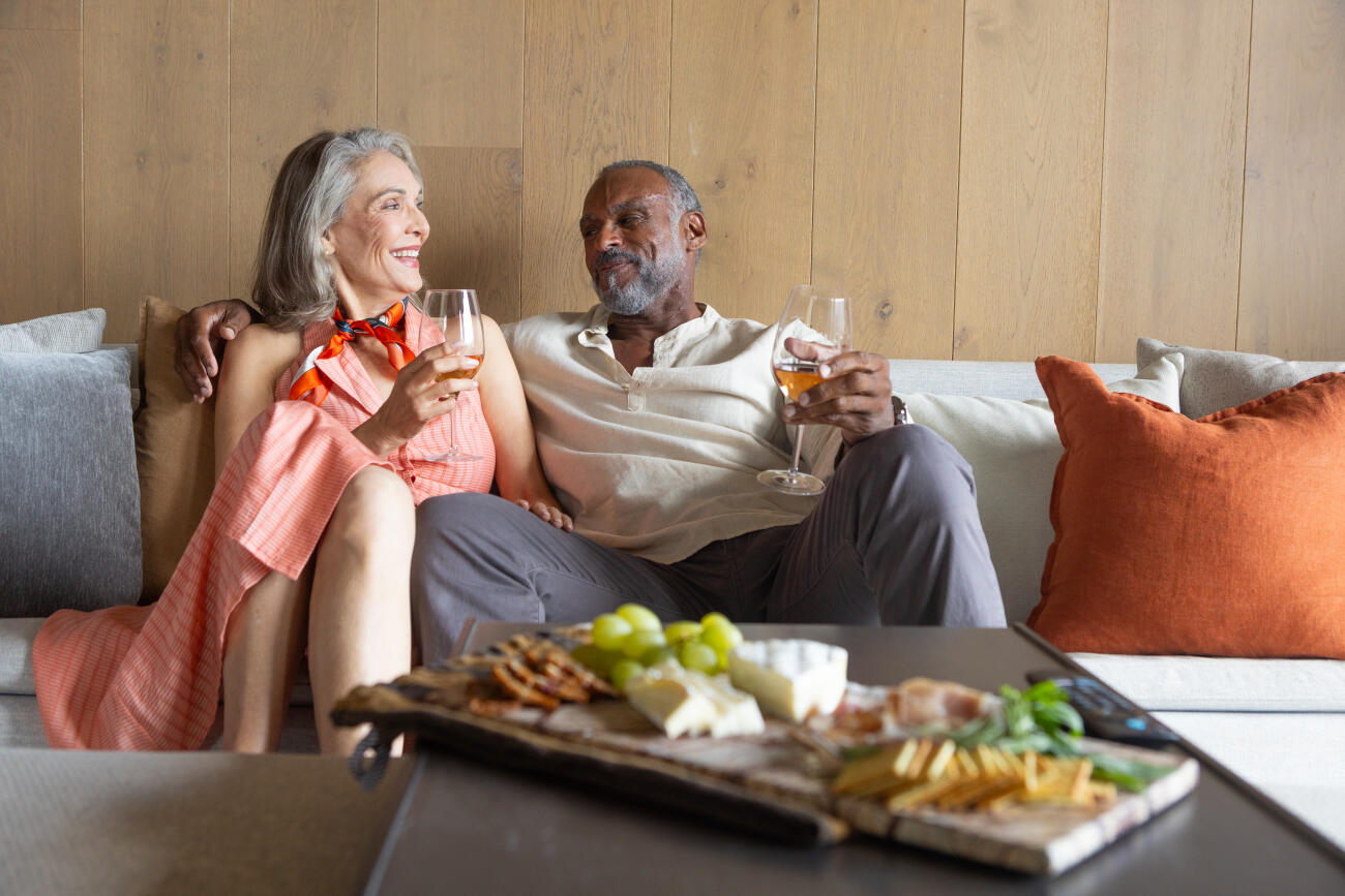 Senior couple enjoying a glass of wine on the sofa