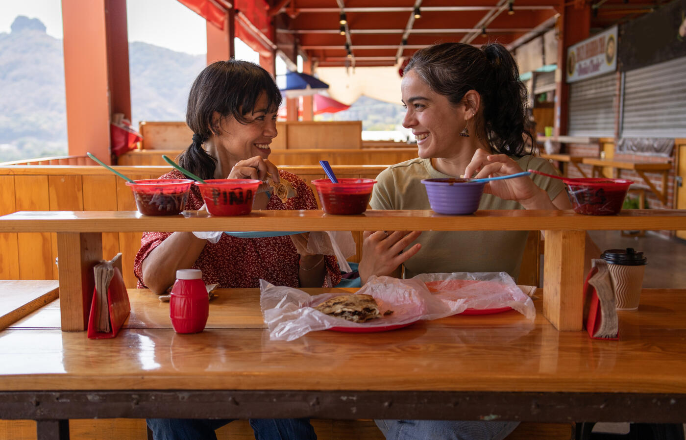 Two women friends trying street food at a food market in Tepoztlán, mexico