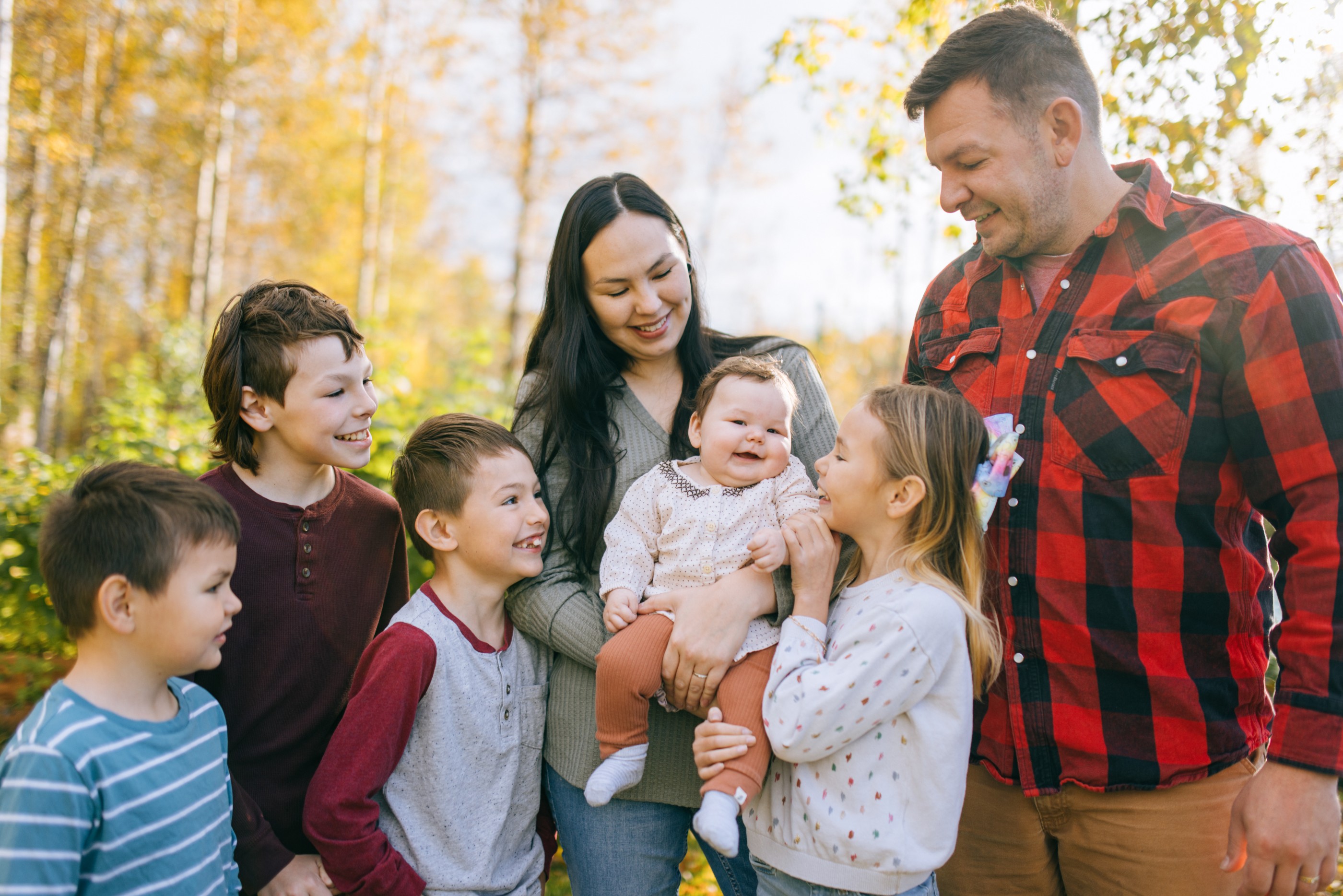 A young family, the father Caucasian and mother Indigenous North American, enjoy time together with their children at their house on a sunny day.  Shot near Palmer Alaska.