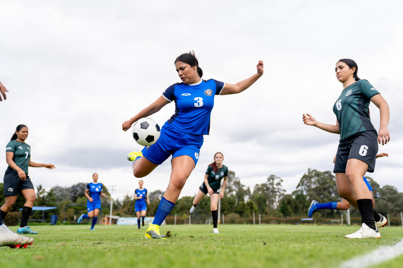 Latin American female soccer taking a shot during a game - sports concept