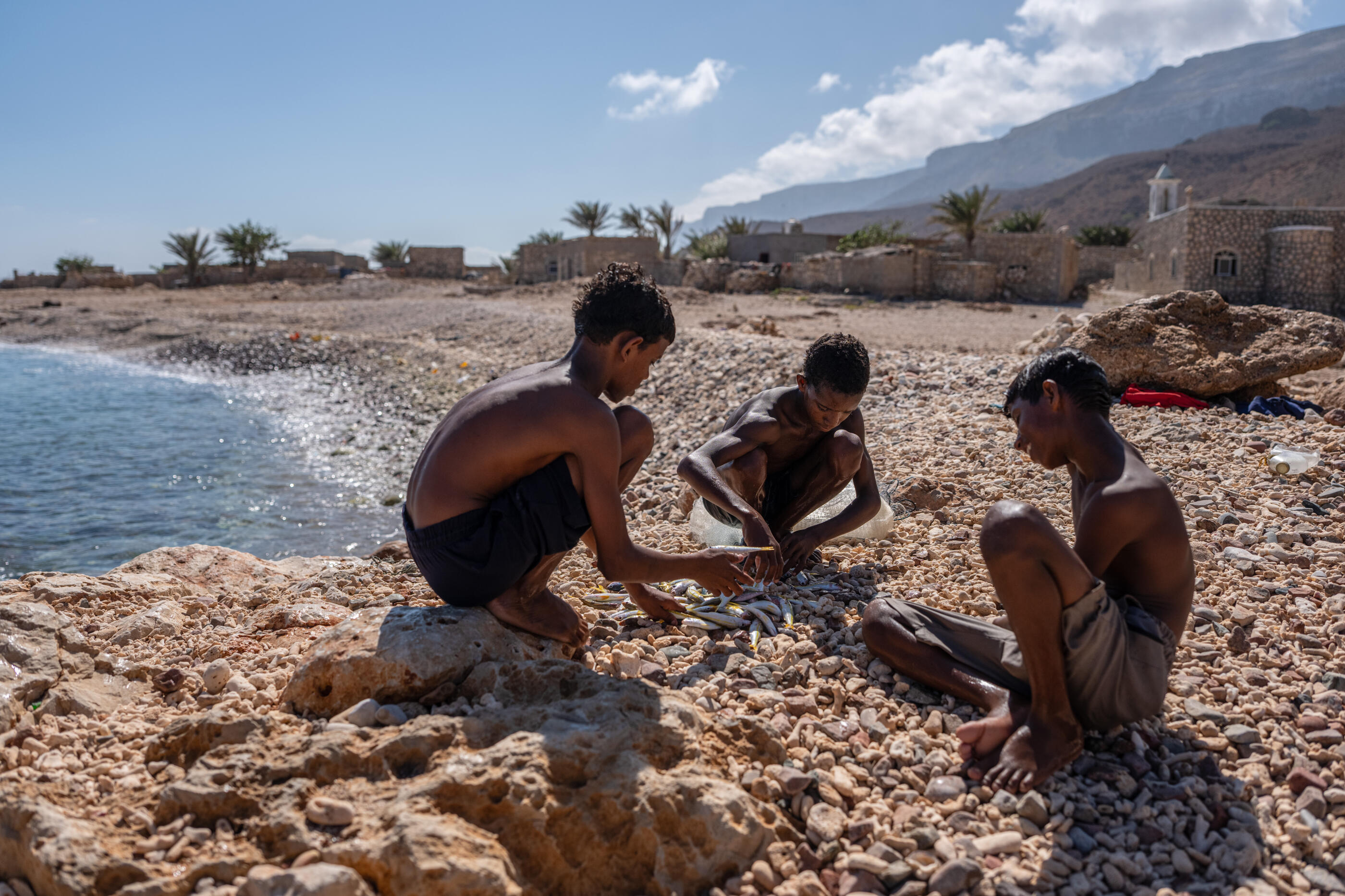 SOCOTRA ISLAND, YEMEN - OCTOBER 12: Boys check their catch after fishing off the beach on October 12, 2025 in Socotra, Yemen. Socotra island, sometimes referred to as the "Galapagos Islands" of the Indian Ocean, lies about 150 miles off the coast of the Horn of Africa and is home to 825 plant species, more than a third of which are only found here. Among them are the otherworldly dragon's blood tree, bottle trees and 11 species of frankincense, 4 of which were classified as critically endangered in March of this year. The intensifying tropical cyclones in this part of the Indian Ocean, fuelled by climate change, has put the island's unique ecosystem at risk. Meanwhile, Yemen's civil war - as well as the region-destabilizing attacks on commercial vessels in the Red Sea - have complicated conservation efforts. (Photo by Carl Court/Getty Images)
