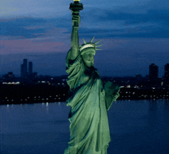 Vertical Screen:Aerial Helicopter Cinematic View of the Statue of Liberty with Manhattan Skyline Cityscape in the Evening. Panorama of New York City Skyscrapers and Jersey City Buildings at Sunset