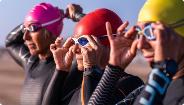 middle-aged women friends sportswomen and open water swimmers prepare in a feel-good environment before entering the sea